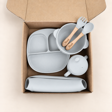Load image into Gallery viewer, Pale grey blue silicone baby feeding set presented in a kraft box with Noah engraved on the wooden spoon and fork
